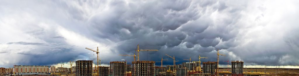 photo of a storm front approaching a large construction project